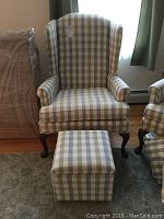 Front view of armchair and ottoman placed on carpet in front of window