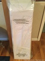 Full view of the shoe organizer in its white sealed packaging, unable to see the assembled product but labeling and packaging clearly visible.