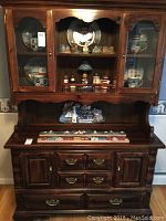 Full view of two piece wood hutch showing upper glass display cabinet and lower cabinet with drawers