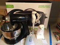 Full view of the lot showing Sunbeam Mixmaster stand mixer with stainless steel bowl and beaters, Rival electric can opener, Toastmaster hand mixer, TRU 18 quart roaster oven box, and manual hand can opener on counter.