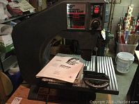 Craftsman 10-inch motorized band saw showing the full saw with metal table and original manuals on top.