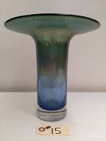 Full view of the art glass vase showing its flared green top and blue base.