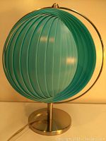 Front angled view showing blue ribbed spherical shade and chrome round base