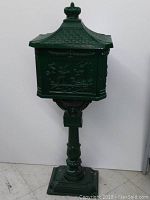 Angled full view of mailbox on pedestal showing roof, body and base