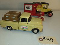 Three diecast advertising trucks in a lineup: CO-OP pickup truck in front, red Campbell's Pork & Beans truck in middle, yellow Home of the Handyman truck in back.