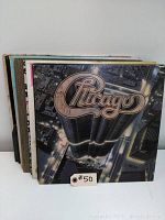 Stack of 9 vinyl LP records with visible Chicago album cover on top, showing album artwork with cityscape and Chicago logo.