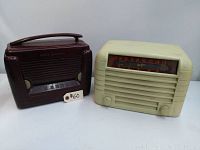 Pair of antique radios, one maroon General Electric and one cream Canadian Marconi Company, side by side showing overall shape and condition