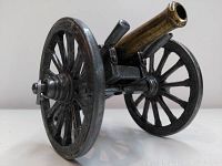 Front angled view showing the brass barrel and pewter wheels of the Civil War cannon replica.