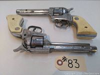 Both vintage metal Stallion 38 toy cap guns showing ivory-colored grips and overall wear.