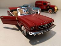 Close-up photo of the 1964 1/2 Ford Mustang diecast convertible with red body and open driver door showing detailed interior and chrome accents.