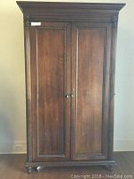 Front view of closed wardrobe showing double panel doors and rope molding trim