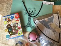 Photo showing the entire gift bag contents including Totoro figurines, Tsum Tsum game, pajamas, and pink thermos with a green gift bag in background.