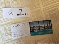 Photo of AquaTerra $100 gift card and 'A Gift For You' envelope with handwritten amount of $100.