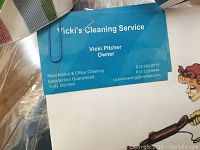 Photo of gift certificate detail with business card of Vicki's Cleaning Service owner Vicki Pitcher, showing contact information and services offered.