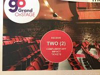 Photo showing theater seating and circle noting two complimentary tickets.