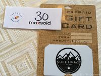 Gift card still on original burlap-patterned packaging showing $50 prepaid amount and North Roast Coffee logo featuring mountain design.