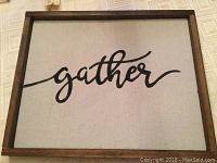 Full view of the framed wall art featuring 'gather' handpainted lettering on fabric.