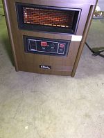 Front view of the portable heater showing wood finish exterior, infrared heating element with visible brick panel, and digital control panel with LED display and control buttons.