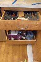 Two drawers open: top with utensil trays, bottom with Breville box and blender parts