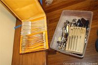 Open case on wood table showing 12 forks and 12 spreader knives in yellow felt slots