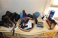 Full view of table with eyeglasses cases, backscratcher, piggy banks, stethoscope and other items arranged in a single lot.