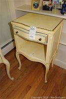 First night stand showing front and drawer closed, with wear to painted finish and curved legs.