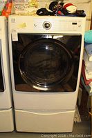 Full view of dryer on pedestal stand, front and top visible