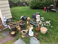 Overall grouping of planters and statues on patio and lawn