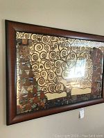 Close-up photo of the framed Gustav Klimt print showing details of the two figures and the swirling tree design.