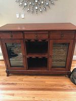 Front view of entire wooden cabinet with drawers, glass doors, and open center racks