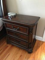Full view of Liberty Furniture night stand with three drawers and carved details, dark wood finish