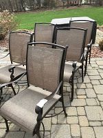 Six chairs on paved patio from front left angle