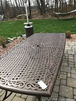 Table corner close-up showing lattice pattern and scrollwork edge