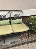 Full side view showing left and center sections of couch with green cushions and decorative backrest.