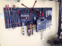 Complete tool assortment mounted on black pegboard showing all included items.