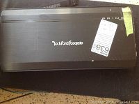 Close-up top view of the black Rockford Fosgate Prime 500 amplifier showing the brand name and model with a label attached.