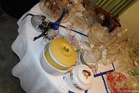 Overview of table with various vintage glassware, porcelain, and Noritake China pieces including the soup tureen and Vaseline glass sugar and creamer.