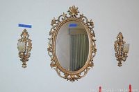 Full set on wall showing vintage oval mirror with gold plastic decorative frame and two matching wall sconces with cut glass globes for candles.