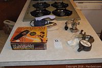 Sunbeam Clipmaster clipper set box with clipper and valve fittings on countertop near gas stove.