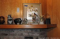 Shelf display showing ceramic squirrel, decorative glass basket, vintage cowbell, Chokin Art duck collection, and framed bird print.