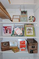 Full view of shelving containing sewing patterns, knitting kits, and vintage cigar boxes.
