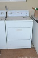 White Kenmore 80 Series clothes dryer with front door closed and visible control panel.
