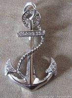 Front view of a silver anchor pendant adorned with clear rhinestones on the fluke tips and top bar, showing the textured rope detail.