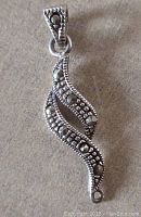 Front view of vintage sterling silver marcasite pendant with curvy design and marcasite stones