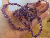Hand holding a 32-inch amethyst chip necklace showing its length and overall shape