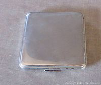 Closed vintage sterling silver compact showing smooth polished surface with slight wear marks