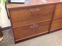 Front view of Madula filing cabinet with two drawer fronts, showing metal handles and lock on lower drawer.