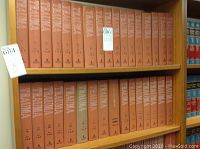 Photo of multiple Trauma volumes in brown cover on a wooden shelf.