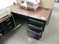 Desk showing wood grain surface top with file folder organizers and three drawers on the right side visible