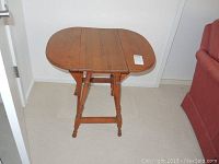 Photo of maple gate leg side table, angled view showing one leaf folded down and the other extended.
